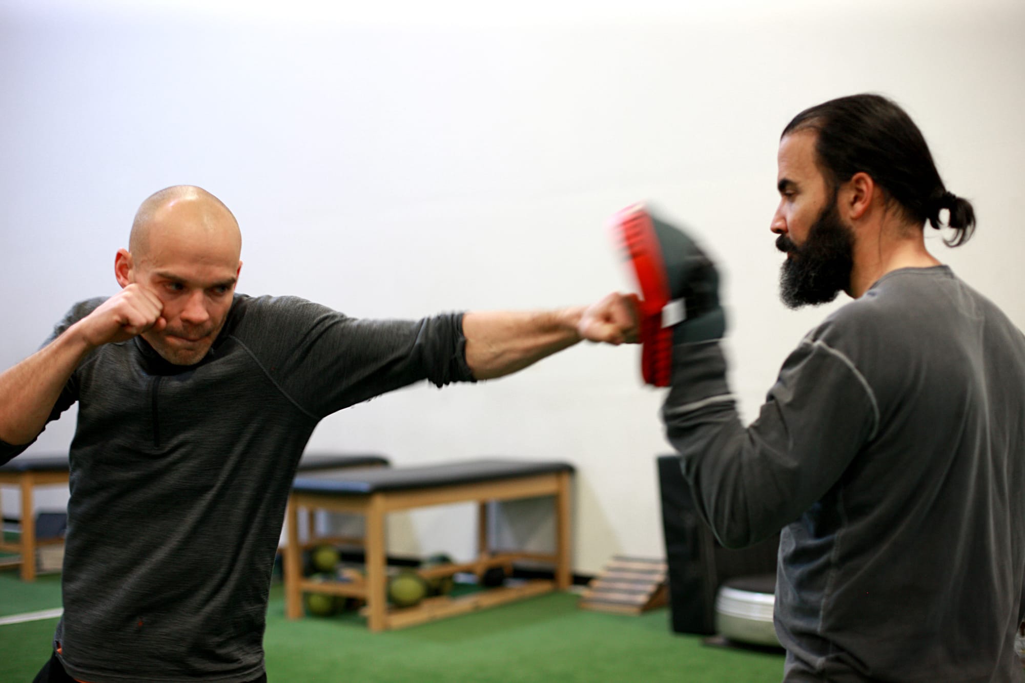 High performance combat athlete training with medicine ball and ground movement drills in athletic studio