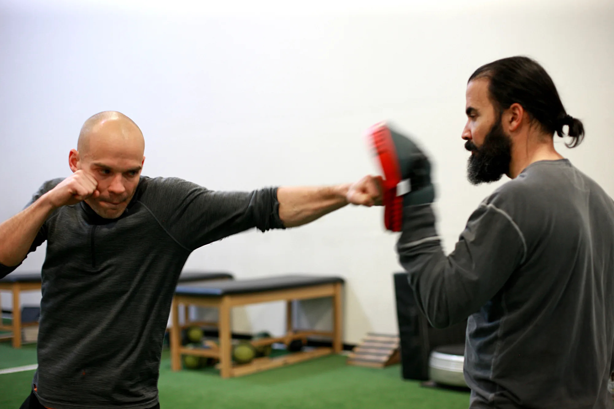 High performance combat athlete training with medicine ball and ground movement drills in athletic studio